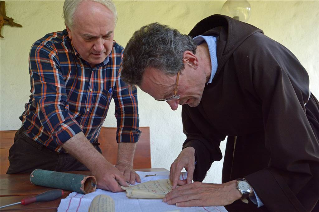 Zeitkapsel am Kapuzinerkloster wird geöffnet und bringt historische Schriften hervor Mindestens 100 Jahre alt ist die Zeitkapsel, die unter dem Türmchen des Kapuzinerklosters gefunden wurde. Nun wurde sie geöffnet. Vier Dokumente mit historischem Wert kamen dabei zum Vorschein. Pater Romuald (r.) versucht sie, zu entziffern.