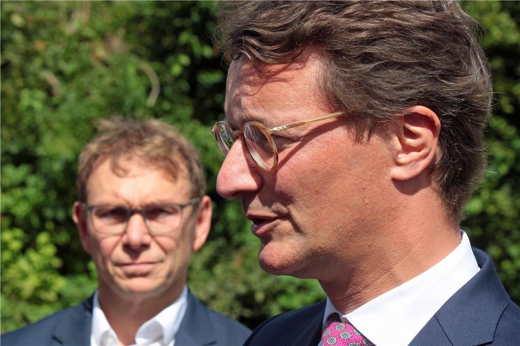 Ministerpräsident Wüst beantwortet Fragen der Medien. Bürgermeister Christ hört im Hintergrund aufmerksam zu.