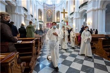 Ministranten prozessieren beim Weihnachtsgottesdienst durch eine Kathedrale. 