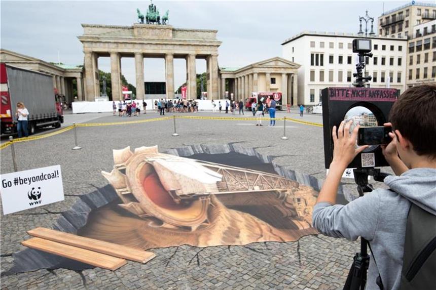 Merkel: Müssen im Klimaschutz wieder besser werden Mit dem 3D-Bild eines Braunkohletagebaus protestieren Umweltschützer in Berlin für eine Veränderung der Umweltpolitik. Kanzlerin Merkel spricht beim „Petersberger Klimadialog“. Foto: Jens Büttner