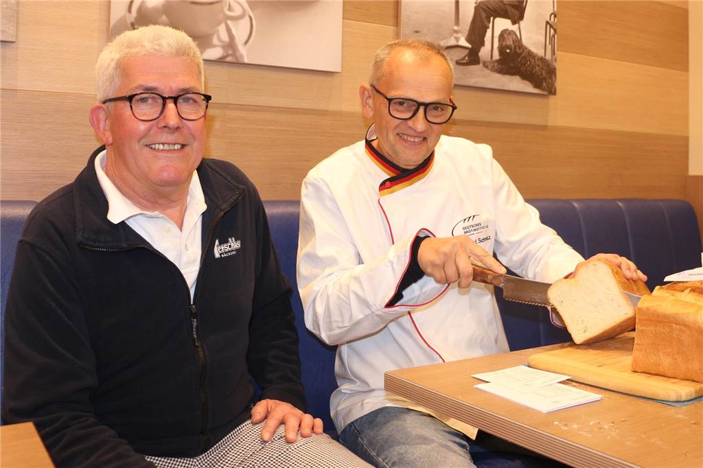 Brotprüfung in Oeding: Innungsbäcker stellen sich dem „Schmalz-Test“ Mit dem Anschnitt des Brotes, natürlich mit einem guten Messer, beginnt der zweite Teil der Prüfung, wie Karl-Ernst Schmalz (r.) erklärt. Punkte werden auf einem kleinen Zettel verteilt. Richard Terschluse wartet unterdessen gebannt auf das Urteil des Prüfers.