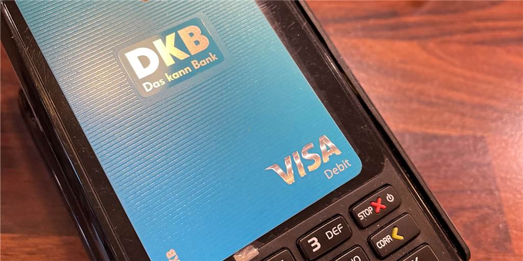 EC-Karten-Aus: Mit Bargeld und Girokarte den Einzelhandel retten Eine Debit-Karte der DKB-Bank liegt auf einem Handy.