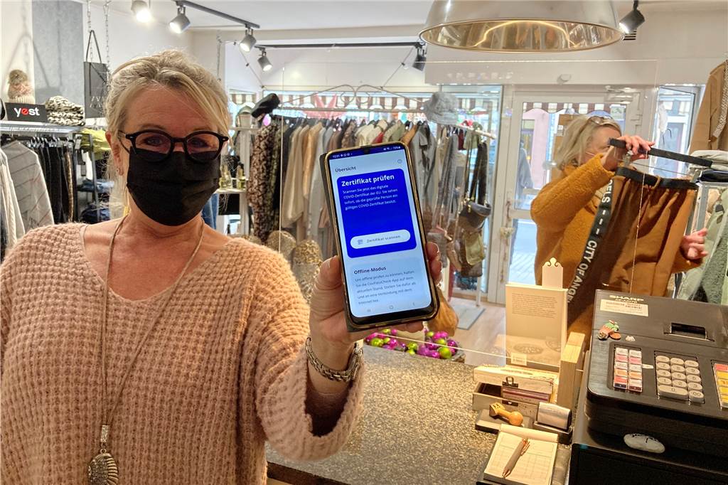 2G-Kontrollen kosten „kleinen“ Einzelhandel mehrere Tausend Euro Mit der Smartphone-App "CovPass-Check" prüft Susanne Hahn, ob die vorgelegten Impfzertifikate gültig sind.