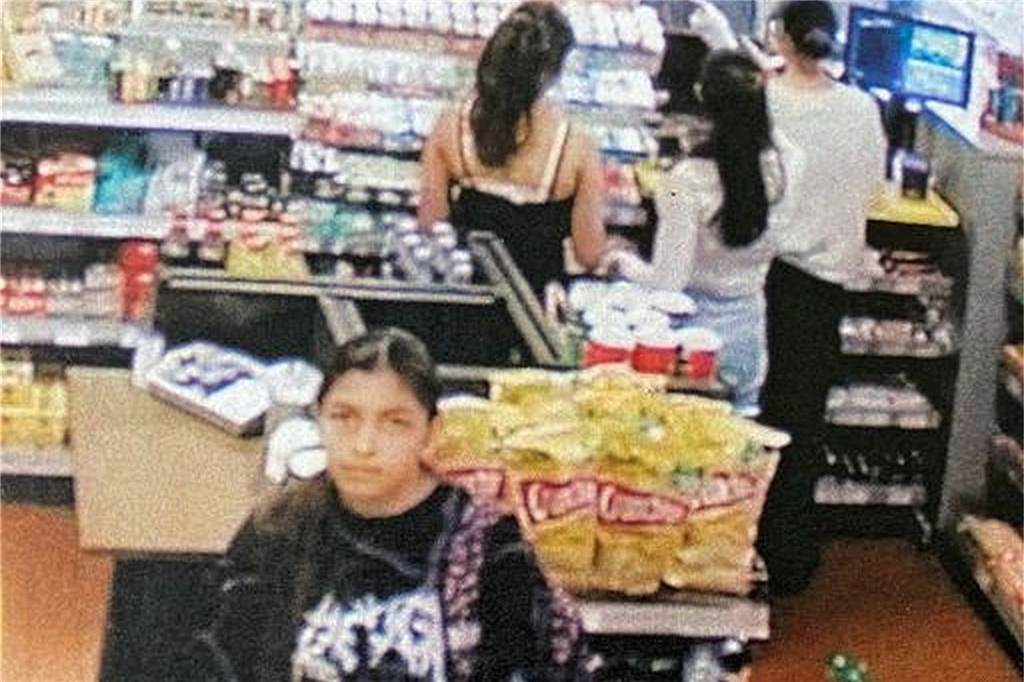 Diebstahl in Tankstelle: Polizei fahndet mit Fotos nach Tätern Eine junge Frau schaut in die Videokamera im Verkaufsraum einer Tankstelle.
