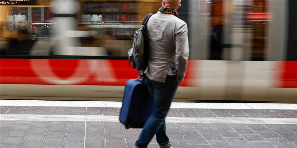 Reisen mit Regios: So klappt die Urlaubsfahrt mit dem 9-Euro-Ticket Ein Fahrgast geht zu einem einfahrenden Regionalzug am Bahnhof.