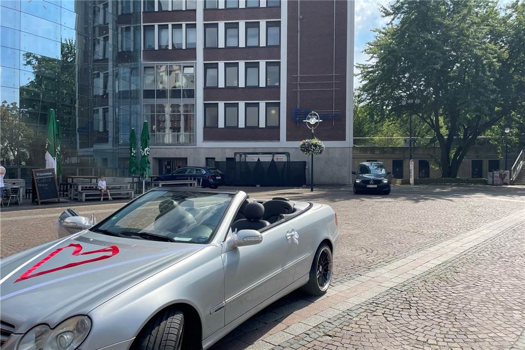 Trauung bei über 30 Grad: Jaqueline und Alina haben geheiratet Ein silbernes Cabrio steht auf dem Friedensplatz. Ein Herz ist mit einem roten Band auf der Motorhaube ausgelegt.