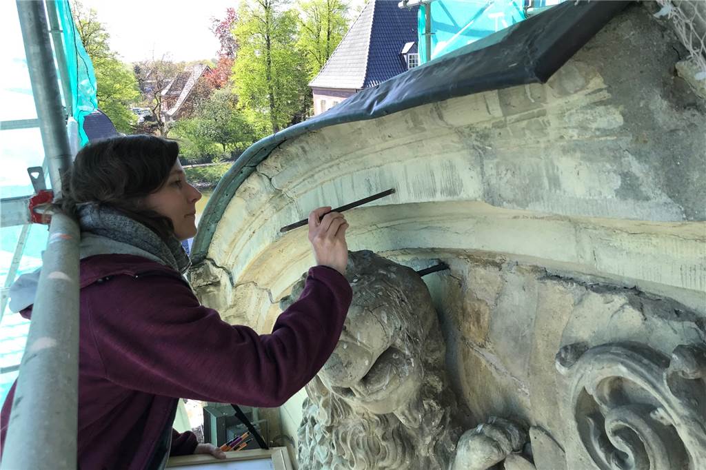 Triumphportal am Schloss: „Ein wunderschönes Schadensbild“ Mit einem Eisen klopft Katja Harmeling den Sandstein ab. Ein heller Klang deutet auf Schäden hin.