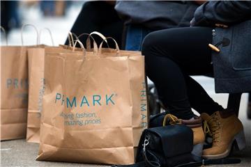 Mit Einkaufstaschen der Modekette Primark sitzen mehrere Frauen auf einer Bank. Foto: A. Burgi/Archiv