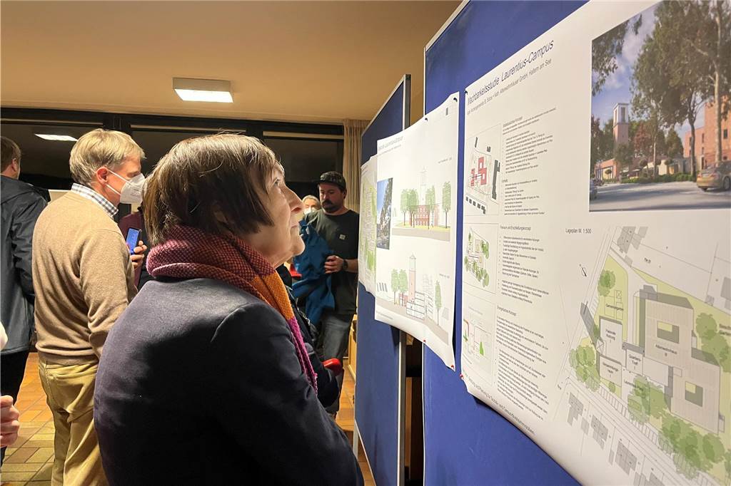 Kirchenabriss in St. Laurentius: Pfarrei baut einen neuen Zukunftsort Besucher des Infoabends schauen sich die Pläne an einer Tafel an.