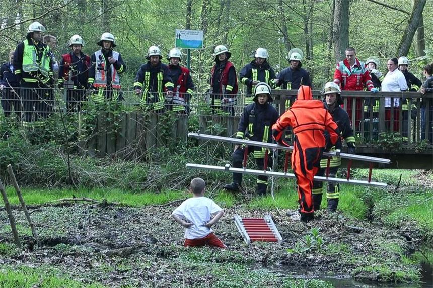 Junge (7) steckte in Schlammloch fest Mit Hilfe einer Leiter und eines Spezialanzugs holte ein Feuerwehrmann den Jungen raus.