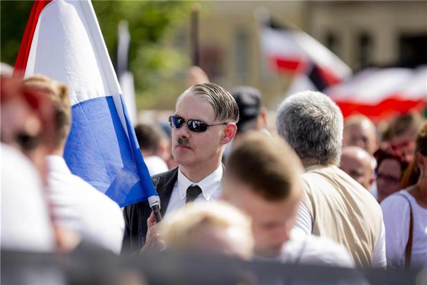 Über 40 Ermittlungsverfahren nach Berliner Neonazi-Aufmarsch Mit Hitlerbart: Ein Teilnehmer der Neonazi-Demonstration anlässlich des 31. Todestages von Rudolf Heß. Foto: dpa