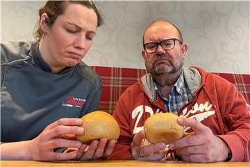 Eine Frau und ein Mann begutachten zwei Brötchen