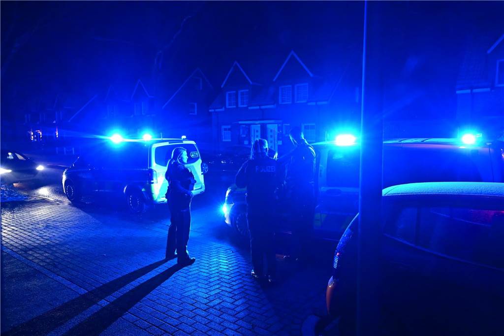 Polizeieinsatz in Recklinghausen: Hubschrauber kreist über König Ludwig Einsatzwagen der Polizei stehen auf einer nächtlichen Straße in einem Wohngebiet. Blaulicht ist angeschaltet. Polizeibeamte stehen auf der Straße.