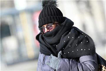 Mit Mütze und Schal schützt eine Touristin in Berlin ihr Gesicht vor der Kälte. Foto: Wolfgang Kumm