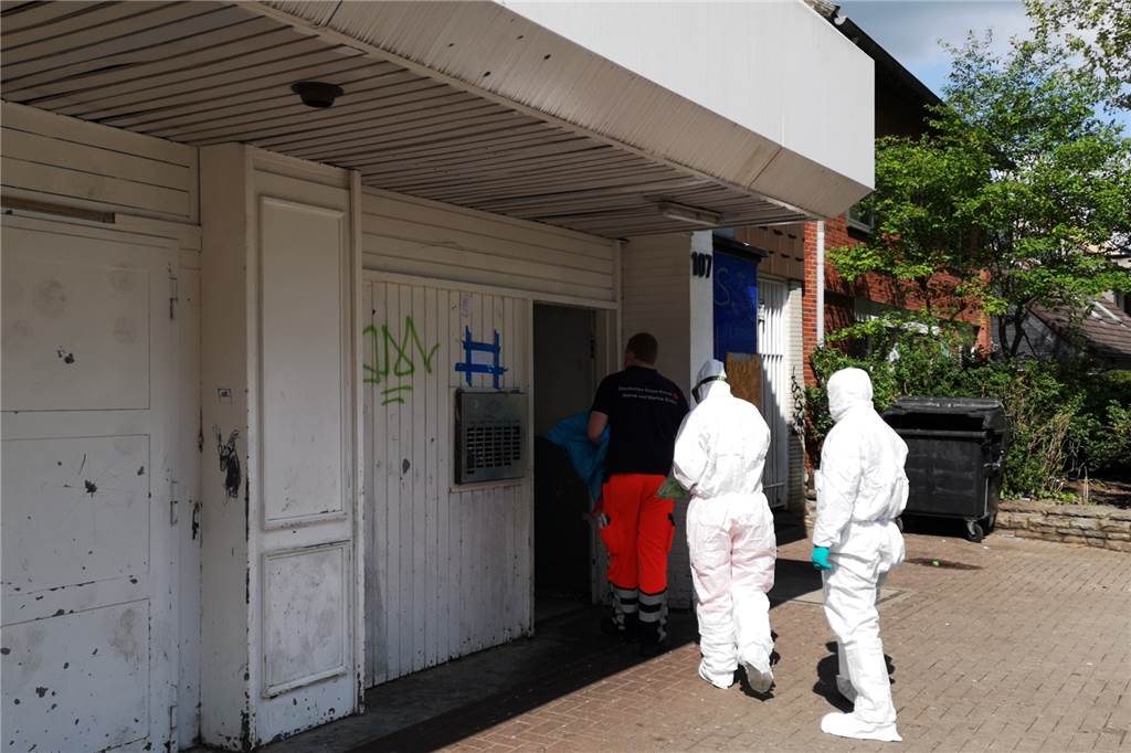 Corona-Massentests in Habinghorst und Merklinde Mit Schutzkleidung betreten zwei Mitarbeiter des DRK und ein Dolmetscher das Haus an der Langen Straße, um mit den Tests zu beginnen.