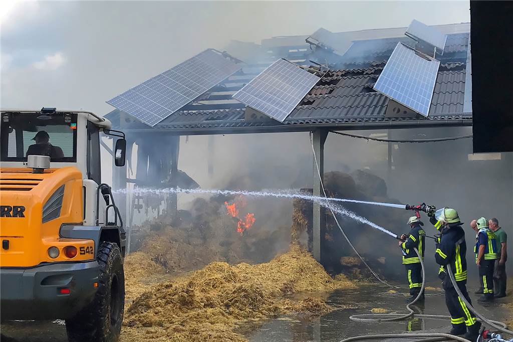 Mit Video: 350 Großballen in Crosewick in Flammen – 200 Rinder in Gefahr Mit schwerem Gerät wurde das Stroh aus der brennenden Halle geholt, um es auf einem angrenzenden Maisfeld abzulöschen.