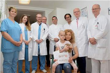 Mit selbstgemalten Bildern bedankten sich die siebenjährige Eli und ihre Mutter beim Team der Klinik am Park (von links): Intensivschwester Maren, Dr. Katina Nicolova, Oberarzt Thilo Schwesinger, Verwaltungsleiter Frank Untenberger, Dr. Volkan Kösek, Dr. Bassam Redwan, Chefarzt Dr. Burkhard Thiel und Oberarzt Christian Begher.
