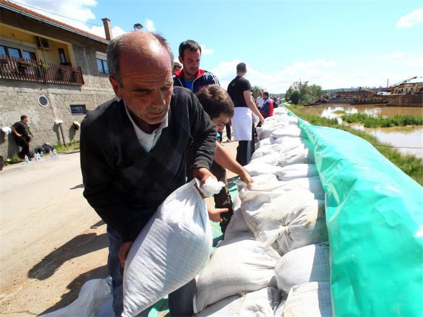 Im Hochwasser-Gebiet wächst die Angst vor Seuchen Mit vereinten Kräften füllen Helfer Sandsäcke, um die Fluten zu stoppen. Foto: Koca Sulejmanovic