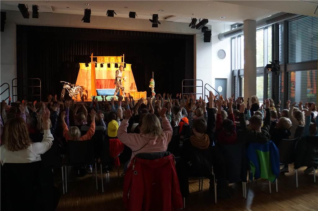 Don Kidschote gastierte an Marienschule in Herbern Die Kinder im Publikum machen mit, während sie zur Bühne schauen.