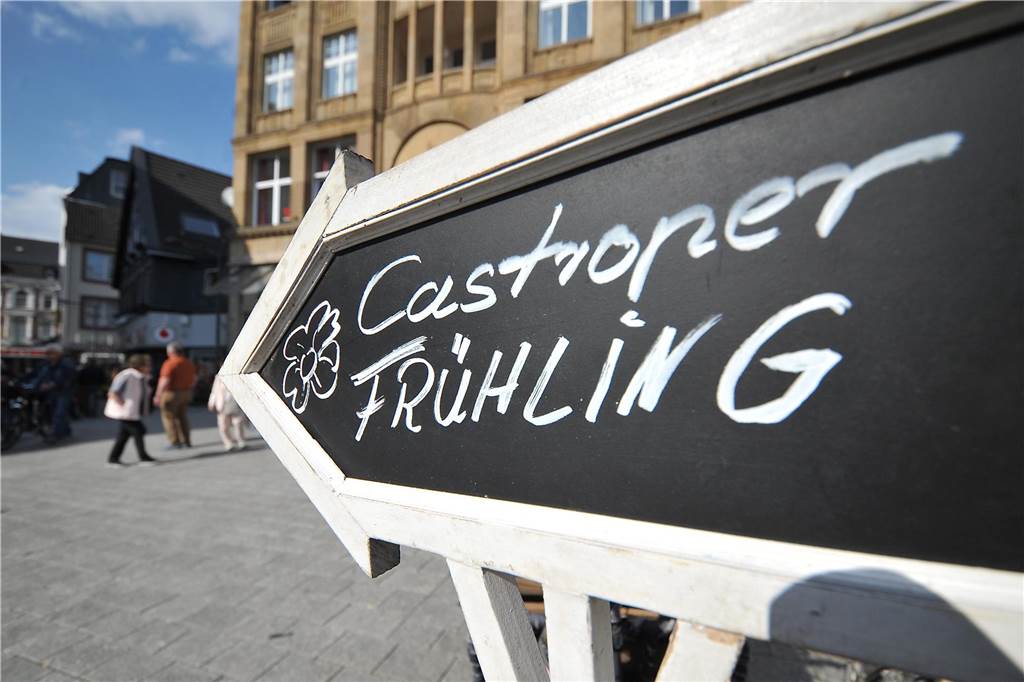 Frühlingsmarkt und verkaufsoffener Sonntag in der Altstadt Auf einen schwarzen Schild steht: "Castroper Frühling". Es zeigt in Richtung der Fußgängerzone in der Castrop-Rauxeler Altstadt.