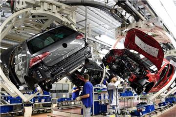 Mitarbeiter arbeiten im Volkswagen-Werk Wolfsburg an einer Fertigungsstrecke des VW Golf 7. Foto: Rainer Jensen