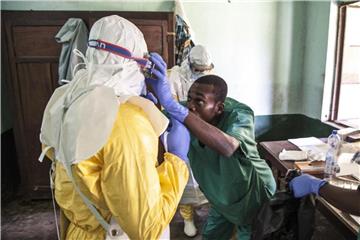 Mitarbeiter des Gesundheitswesens ziehen in einem Behandlungszentrum Schutzausrüstungen gegen Viren an, bevor sie Patienten in der Isolationsabteilung behandeln. Foto: Mark Naftalin/UNICEF/AP
