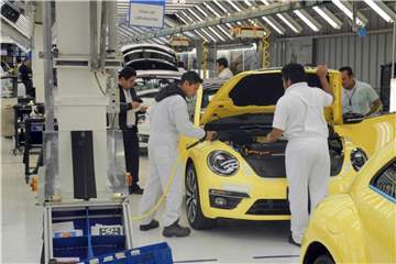 Mitarbeiter des VW-Werks in Puebla montieren einen Beetle. Foto: Denis Düttmann