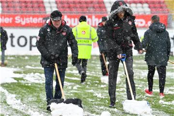 Mitarbeiter räumen das Spielfeld in Kaiserslautern vom Schnee. Foto: Uwe Anspach
