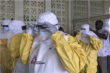 Mitarbeiter von Ärzte ohne Grenzen bereiten sich in Schutzanzügen, darauf vor Ebola-Patienten in einem Krankenhaus in Mbandaka zu behandeln. Foto: Louise Annaud