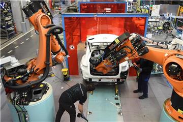 Mitarbeiter von Mercedes-Benz überwachen im Werk in Bremen, wie ein Roboter in das C-Klasse Hybrid Modell eine Batterie einsetzt. Foto: Carmen Jaspersen