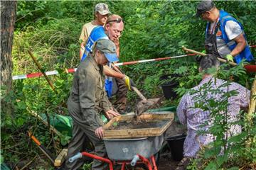 Mitglieder der Arbeitsgemeinschaft Luftfahrtarchäologie durchsieben den Waldboden nach Teilen eines sowjetischen Kampfflugzeuges IL-2. Foto: Patrick Pleul