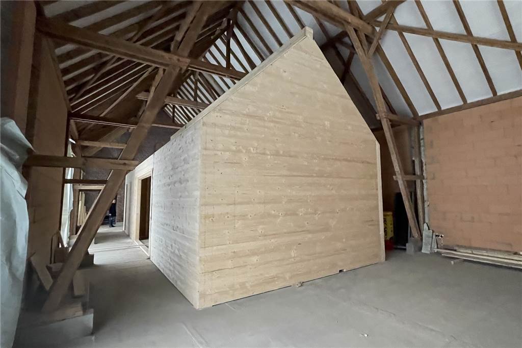 Es ist geschafft: Neues Holzhaus steht in der „Tourismus-Scheune“ Mitten in der Scheune steht ein Holzhaus. Hier wird es künftig Vorträge geben.