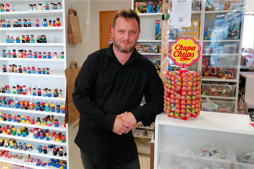 Wie ein Paar die große Liebe im Bus gefunden hat Zu sehen ist Markus Bosshammer in einem dunklen Hemd der an der Theke seines Ladens "BricksBoss" anlehnt.