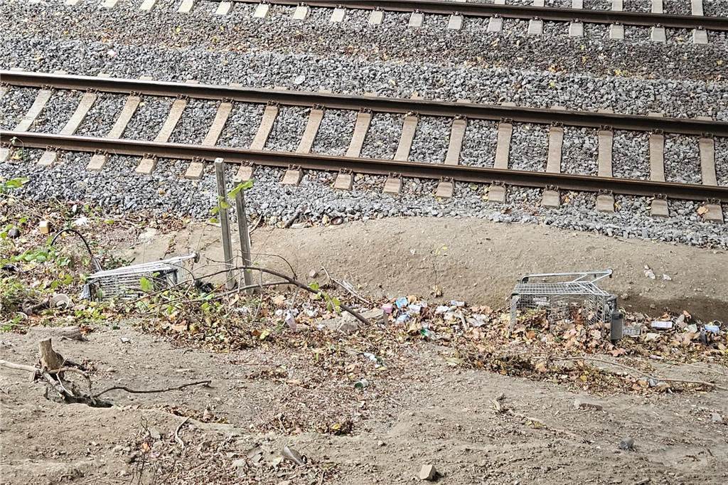 Zwei Einkaufswagen liegen umgekippt an der Böschung zu den Bahngleisen.