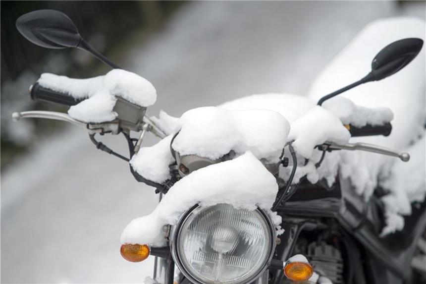 Motorrad überwintert draußen: Batterie ausbauen Motorräder vertragen Schnee und Kälte, Batterie aber nicht. Foto: Arno Burgi/dpa