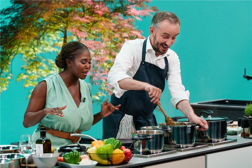 Jan Böhmermann über seine Kochkünste: „Sehr viel mit Schweinemett“ Motsi Mabuse (l), Tänzerin, und Jan Böhmermann (r), Satiriker, stehen in der Küche von «Böhmi brutzelt» am Herd (undatierte Aufnahme). Am 24.07.2021 ist bei ZDFneo erstmals Böhmermanns neue Kochsendung zu sehen, in der der Moderator mit wechselnden Gästen Essen zubereiten und plaudern will.