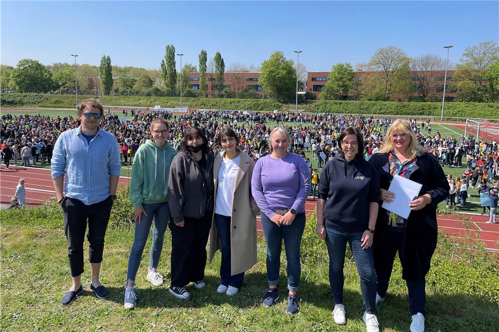 Frieden für alle! 2000 Castrop-Rauxeler Schüler fordern Ende der Kriege Musiklehrer Finn Ole Steffen mit Lena, Hevin und Nehir aus den Schülervertretungen von ASG und WBG, den Lehrerinnen Sonja Alt und Simone Coring sowie Katrin Lasser-Moryson (v.l.), die stellvertretende Bürgermeisterin, vor über 2000 Schülern im Stadion an der Bahnhofstraße.