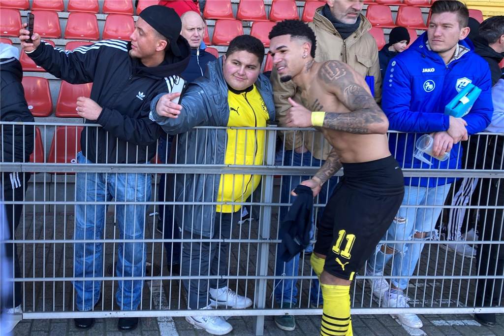Justin Njinmah macht ein Selfie mit BVB-Fans.