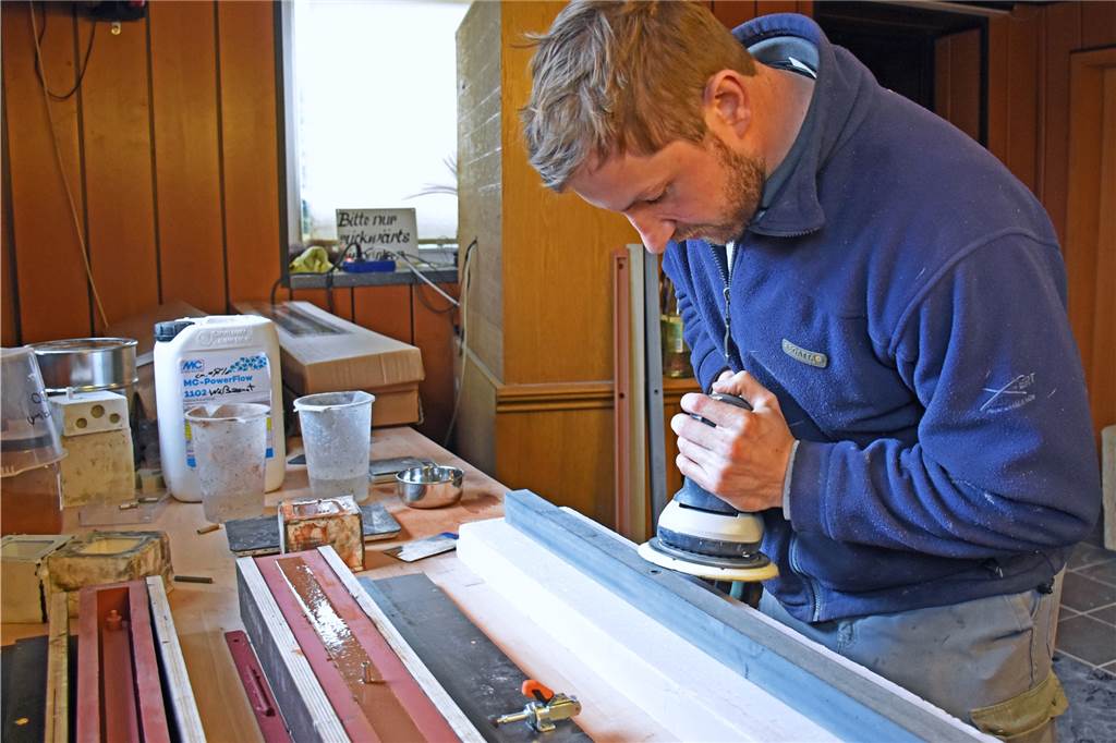 Jens Maaßen stellt in seiner Manufaktur Hausnummern, Fensterbänke und Lampen aus Beton her Nach dem Gießen der Form wird der Beton geschliffen.