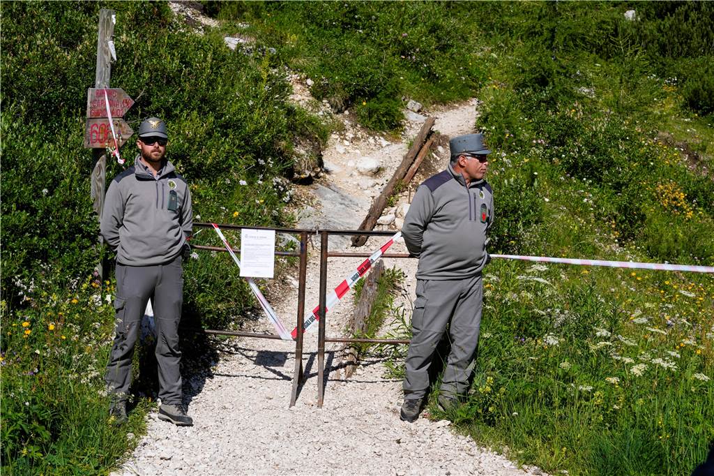 Wandern in den Bergen: Neue Gefahren durch den Klimawandel Beamte der italienischen Finanzpolizei blockieren den Zugang zum Berg Marmolata und zum Punta-Rocca-Gletscher in den italienischen Alpen.