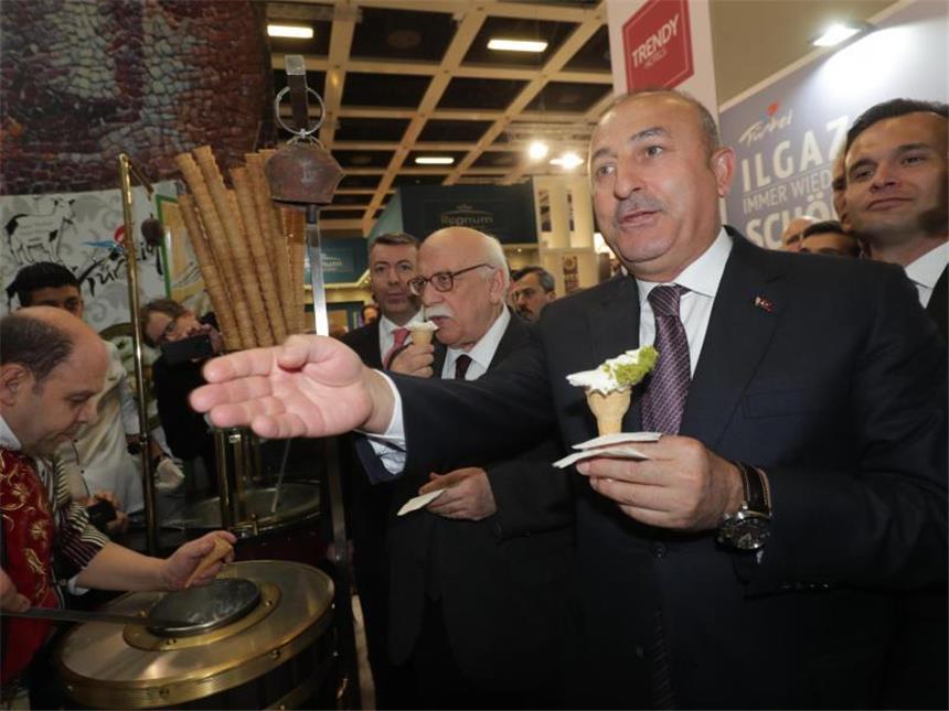 Deutsch-türkische Spannungen: Gabriel zieht Grenze Nach dem Treffen mit Sigmar Gabriel besucht der türkische Außenminister Mevlüt Cavusoglu die Reisemesse ITB in Berlin und holt sich an einem türkischen Stand ein Eis. Foto: Michael Kappeler