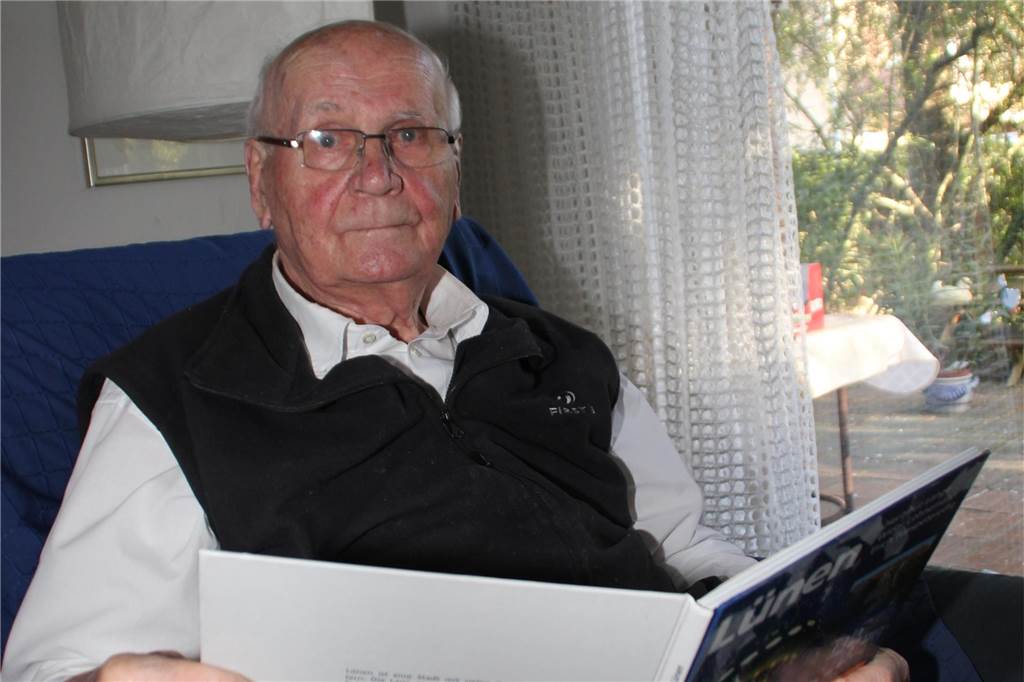 Bernhard Siegmund Strauch feiert bald 90. Geburtstag Bernhard Siegmund Strauch sitzt in seinem Wohnzimmer im Sessel und hält ein Buch über Lünen in der Hand.