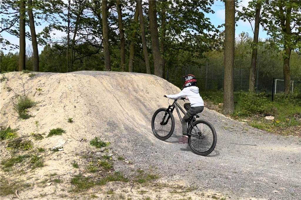 Pumptrack, Dirtbikes und Rampen: So funktioniert der Bikepark Johanna Melchers fährt mit einem Dirtbike auf einen großen Hügel.