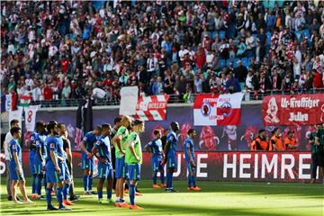 Nach der Niederlage in Leipzig stehen die Wolfsburger Spieler deprimiert vor ihren aufgebrachten Fans. Foto: Jan Woitas