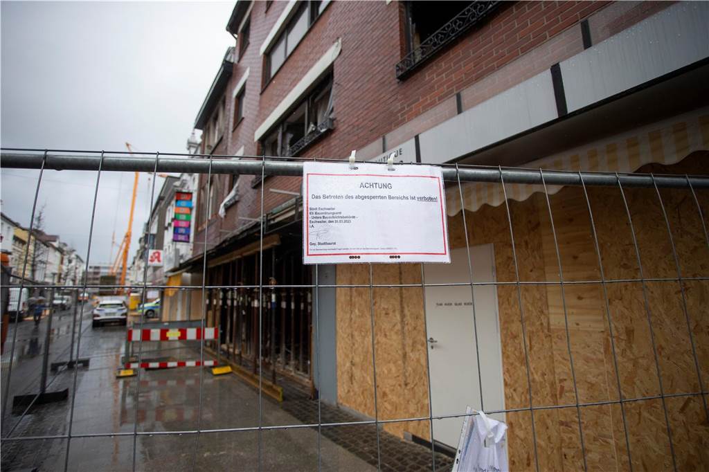 Explosion in Fußgängerzone: Verletzte weiter in Lebensgefahr An einem Absperrgitter vor dem beschädigten Gebäude in der Neustraße hängt ein Schild mit der Aufschrift: «Achtung das Betreten des abgesperrten Bereichs ist verboten»