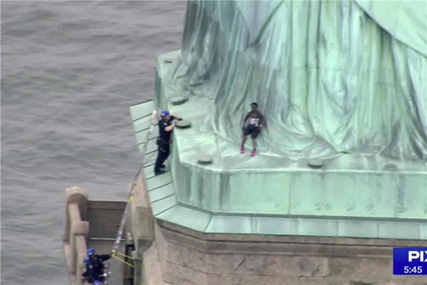Trump-Kritiker klettern auf die Freiheitsstatue Nach US-Medienberichten wurden sieben Demonstranten festgenommen. Foto: PIX11