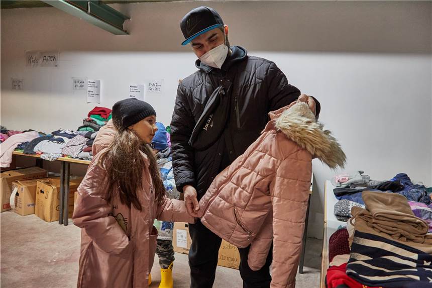 Flüchtlinge aus der Ukraine in Dorsten: So funktioniert es vor Ort Der ukrainische Flüchtling Mohamed Jazara steht mit seiner Tochter Jasmina in der Kleiderkammer in Rissen und betrachtet einen Mantel.