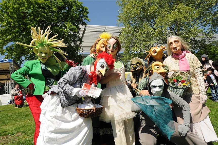 Großes Kulturvolksfest steigt am 1. Mai am Festspielhaus in Recklinghausen Neun völlig verkleidete Künstler stehen vor dem Festspielhaus in Recklinghausen auf der grünen Wiese und schauen in die Kamera.