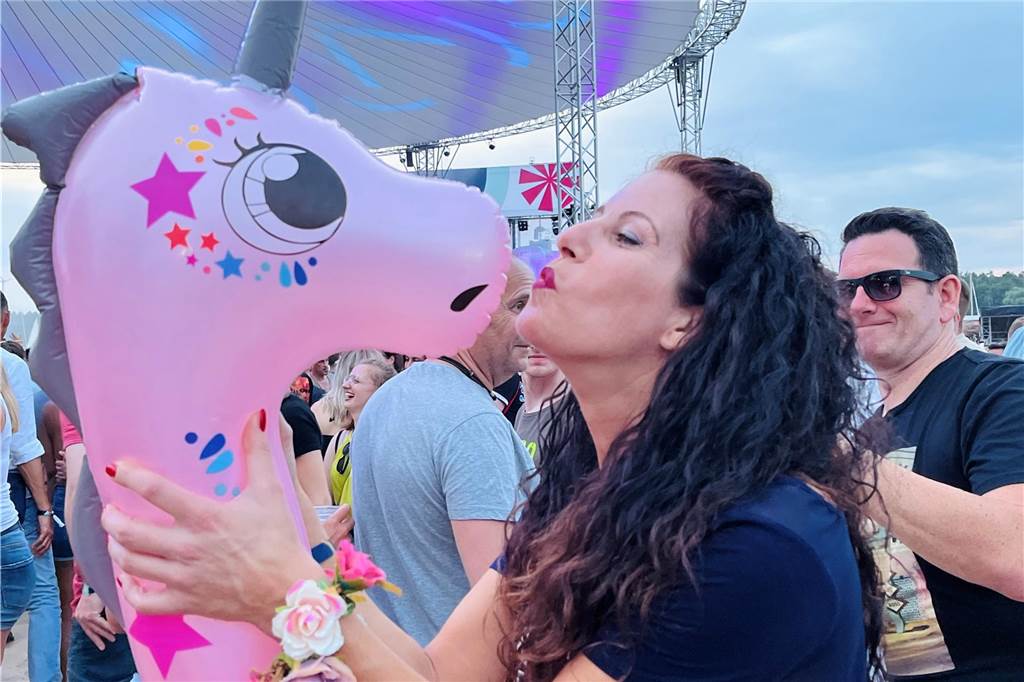 Eine Frau küsst ein Einhorn