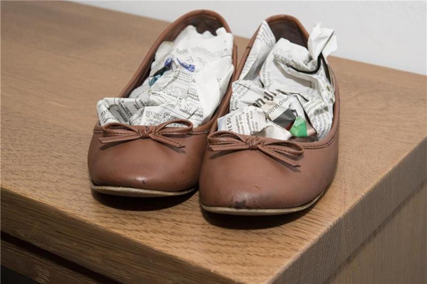 Schuhe nach Sommergewitter nicht föhnen Nasse Schuhe werden am besten mit Zeitung ausgestopft. Sie nimmt die Feuchtigkeit auf. Foto: Robert Günther